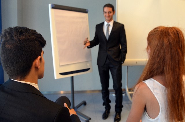 ミーティングで説明する男性　ビジネスの場では、論理的に英語で説明する力が求められる